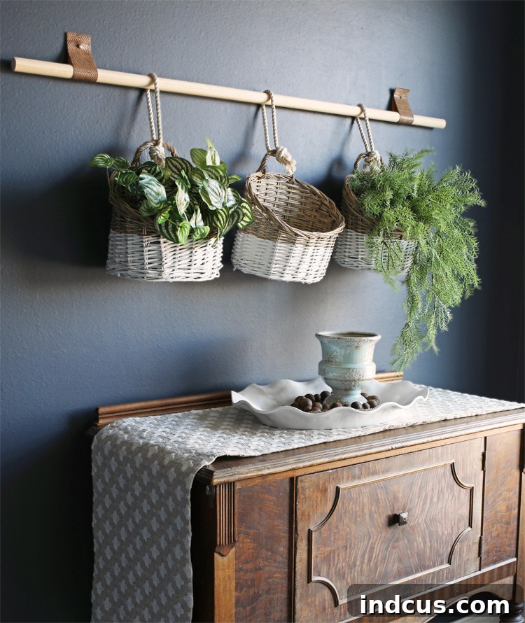 Craft Your Own Basket Wall Art 6 Completed DIY basket wall hanging with three baskets on a wooden dowel, featuring leather straps