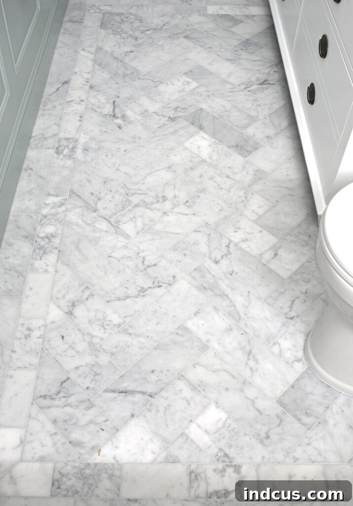 Stunning herringbone pattern marble floors in the newly renovated bathroom, adding luxury and texture