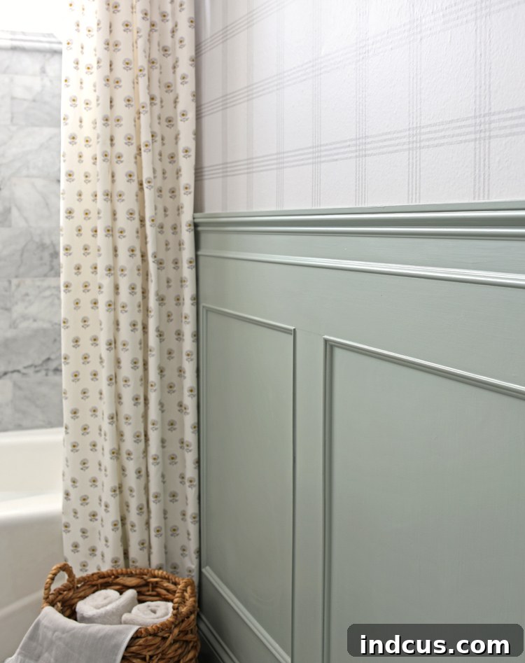 Elegant wainscoting painted in a muted green, adding charm and a classic touch to the bathroom