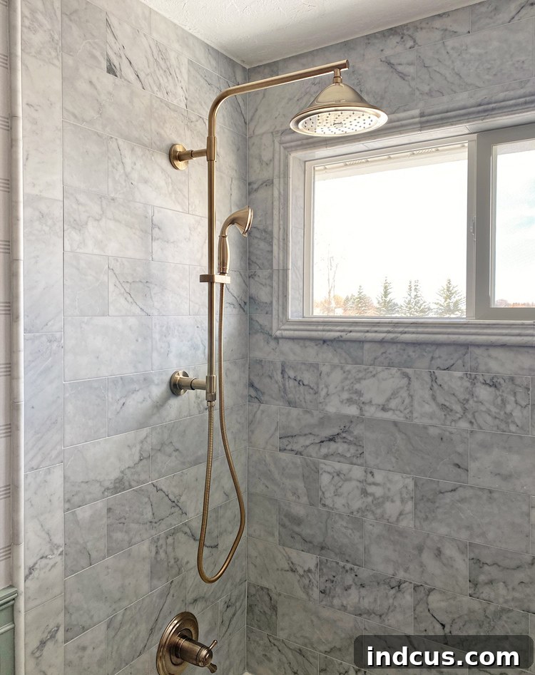 Exposed pipe shower column with a large shower head and a handheld attachment in a stylish bathroom