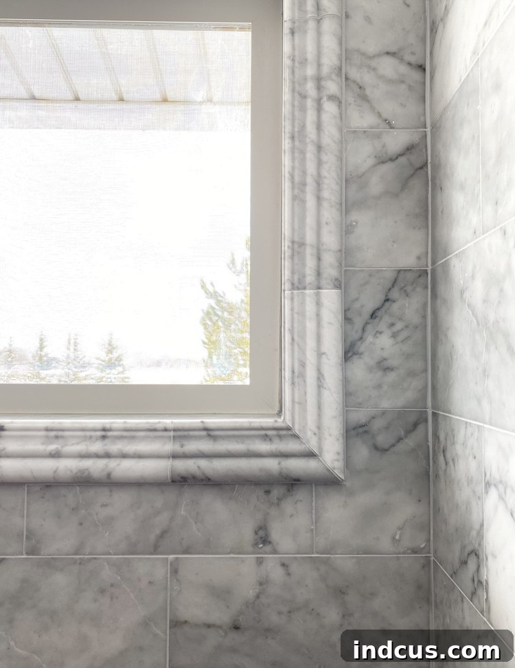 Close-up of a meticulously crafted marble crown trim around a window, showcasing precise miter cuts