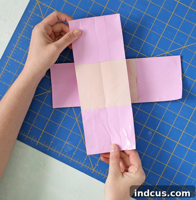 Two Duck Tape strips for inner layers joined to form a 'T' shape, with sticky sides facing up.
