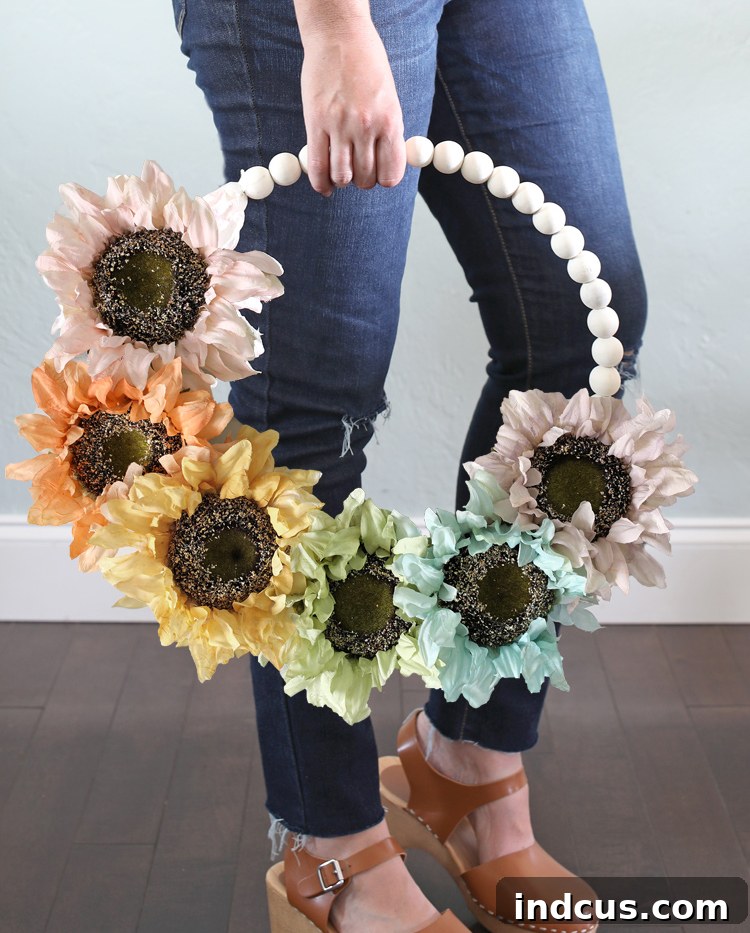 Vibrant rainbow sunflower fall wreath on a door, showcasing painted silk flowers on a wood bead base