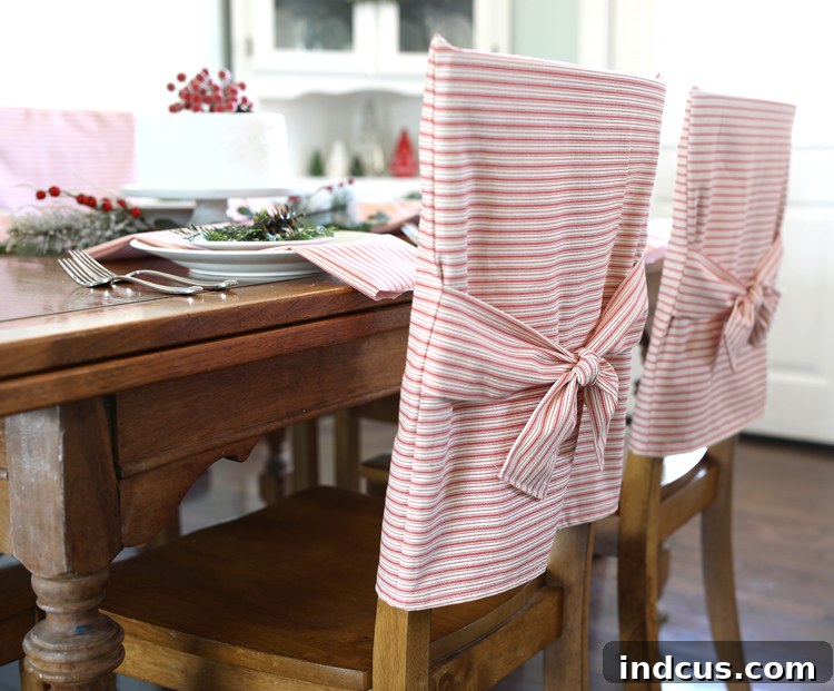 Finished red and white striped holiday chair cover tied with a decorative knot on a dining chair.