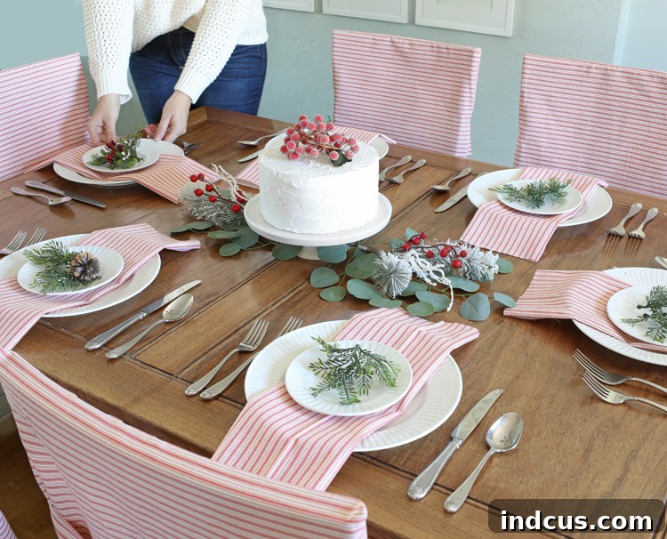 Beautifully decorated holiday dining table with DIY red and white striped chair covers.