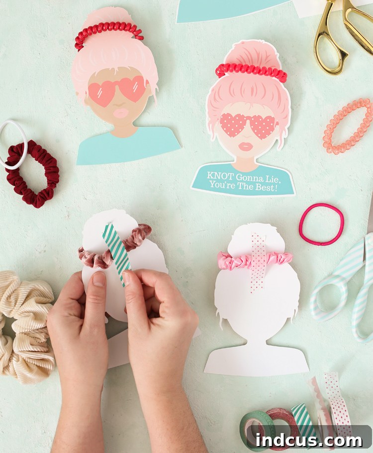 Close-up of a finished scrunchie Valentine card showing the hair tie wrapped around the character's bun, secured with tape.