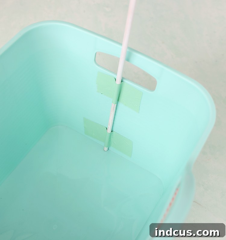 Attaching wooden dowels to a gift basket for a custom banner to keep kids busy this summer