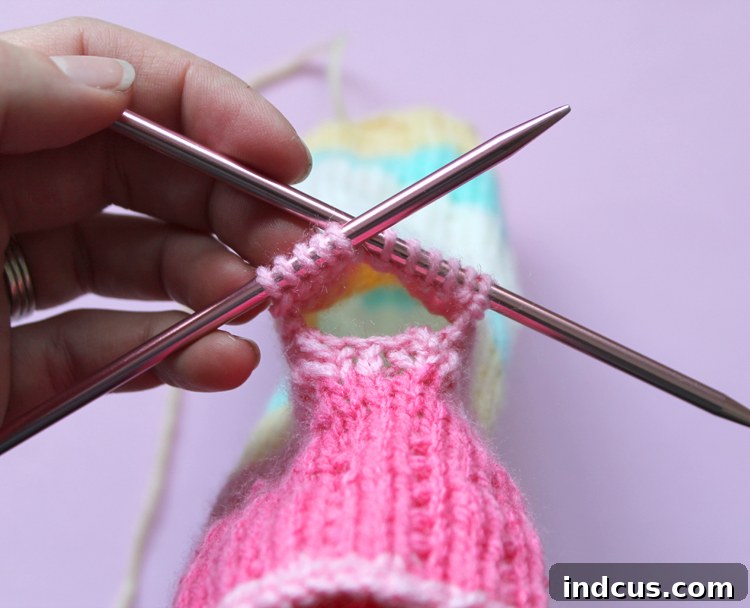 Thumb Gusset Pick Up Stitches How to knit fingerless mitts, showing the pickup of thumb stitches from waste yarn, ready to be worked.