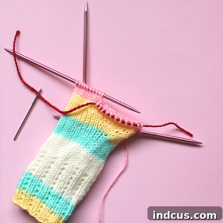 How To Make A Thumb Hole in Knitting Mitts Knitting pattern showing how to use waste yarn to create a thumb hole in fingerless mitts, preparing for the main body.