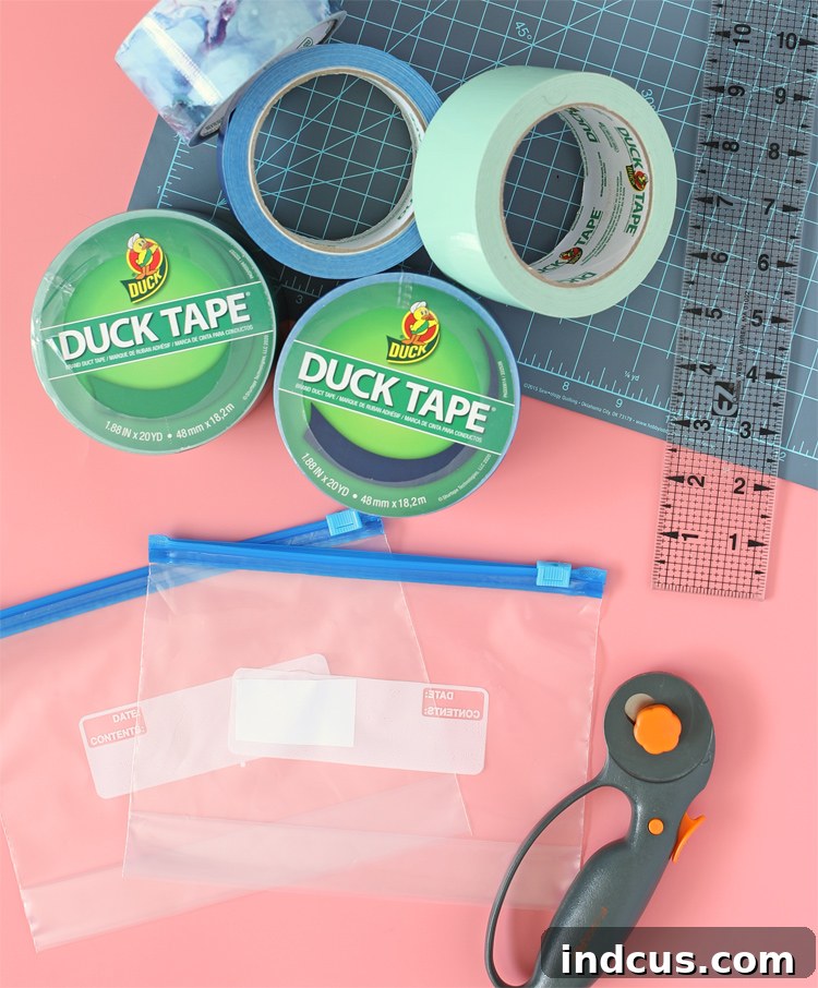 A collection of crafting tools and materials including rolls of colorful Duck Tape, a clear plastic slide-top bag, and a rotary cutter with a mat.