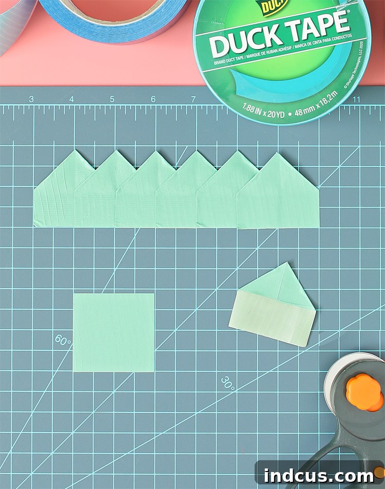 Detailed image showing a piece of Duck Tape folded into a 'house' shape, exposing a sticky strip at the bottom.