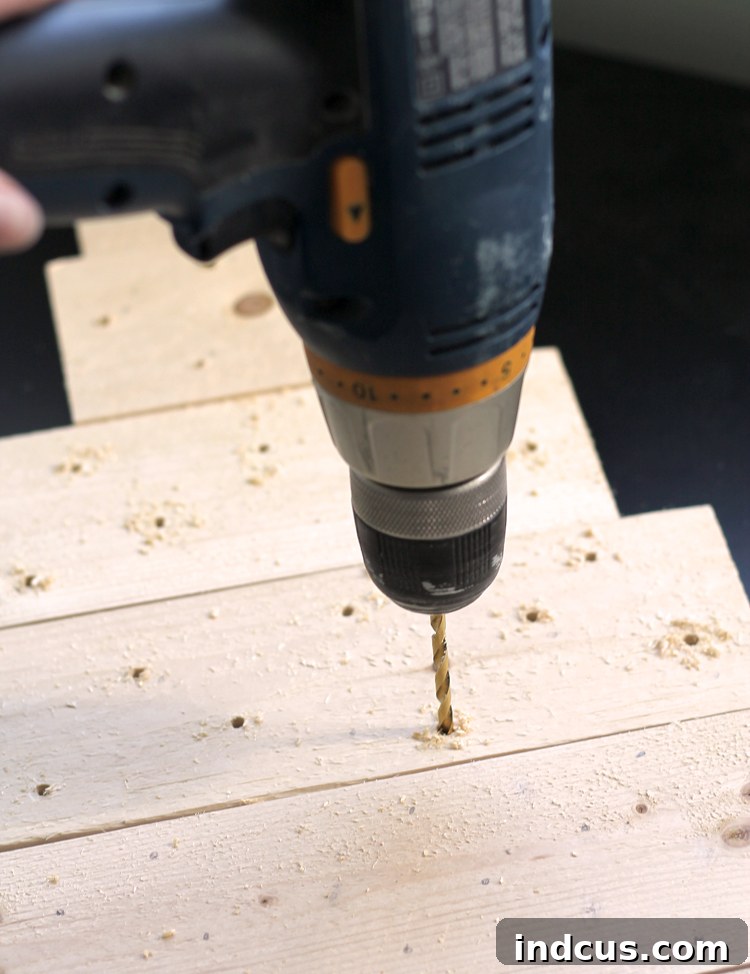Drilling holes into a pallet wood tree for Christmas lights