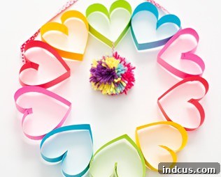A DIY rainbow paper heart and pom-pom wreath, a bright and cheerful Mother's Day decoration.