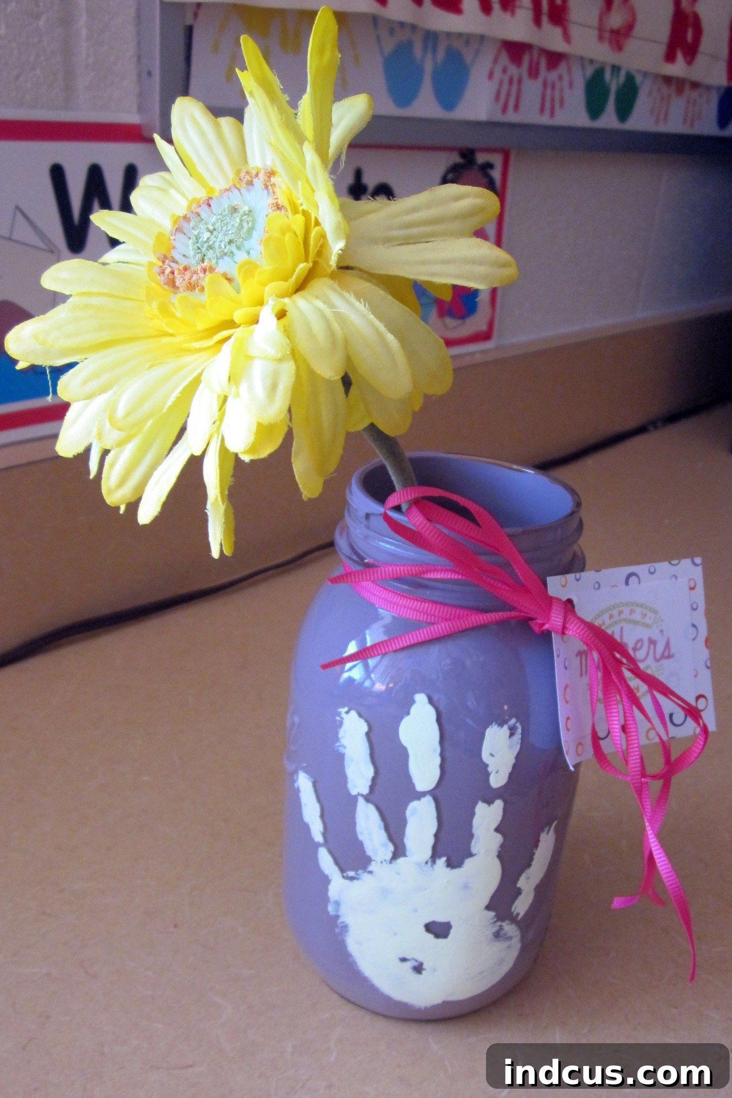 A beautiful handprint mason jar vase for Mother's Day, elegantly holding a bouquet of fresh flowers.