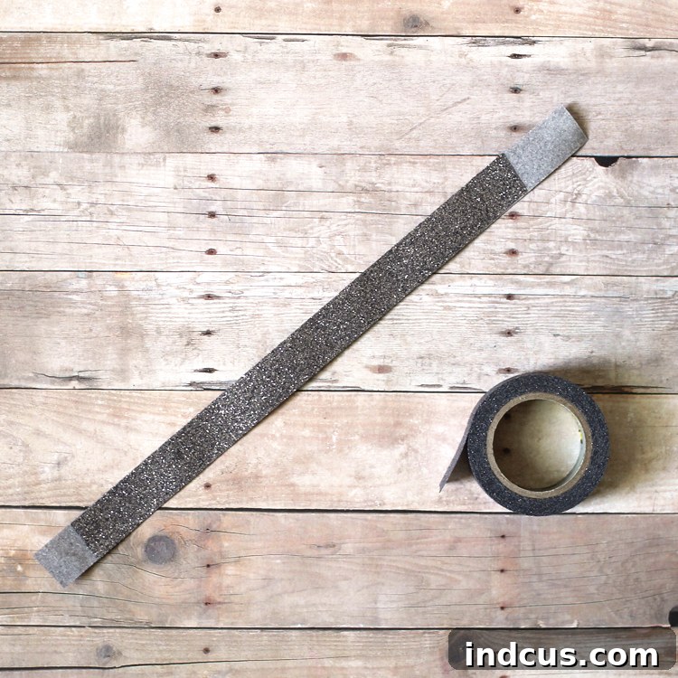 Two pieces of glitter washi tape stuck together to form a sturdy handle, demonstrated for a luminary craft.