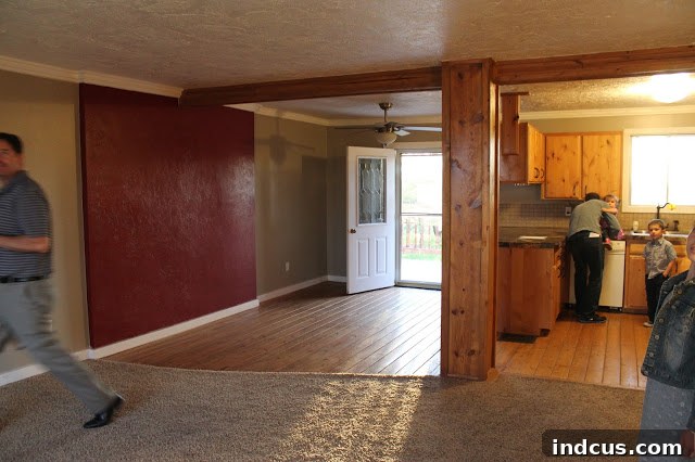 Kitchen before renovation with a prominent red wall and problematic pillar