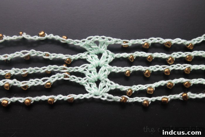 Close-up of completed shell stitches connecting beaded crochet strands
