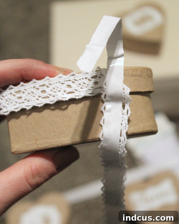 Applying lace tape to the edges of a paper mache heart box