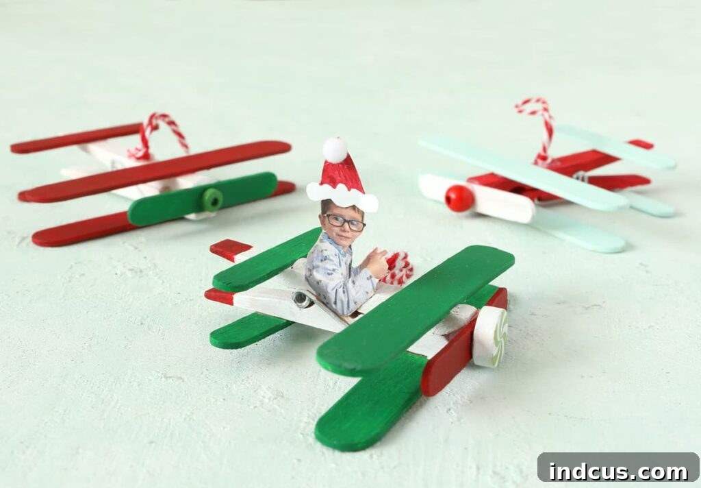 DIY popsicle stick airplane Christmas ornament, featuring a child's photo as the pilot