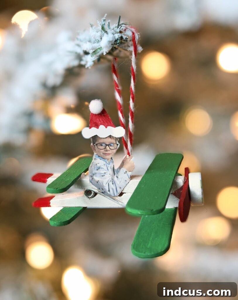 Finished airplane popsicle stick Christmas craft with a child's photo as the pilot