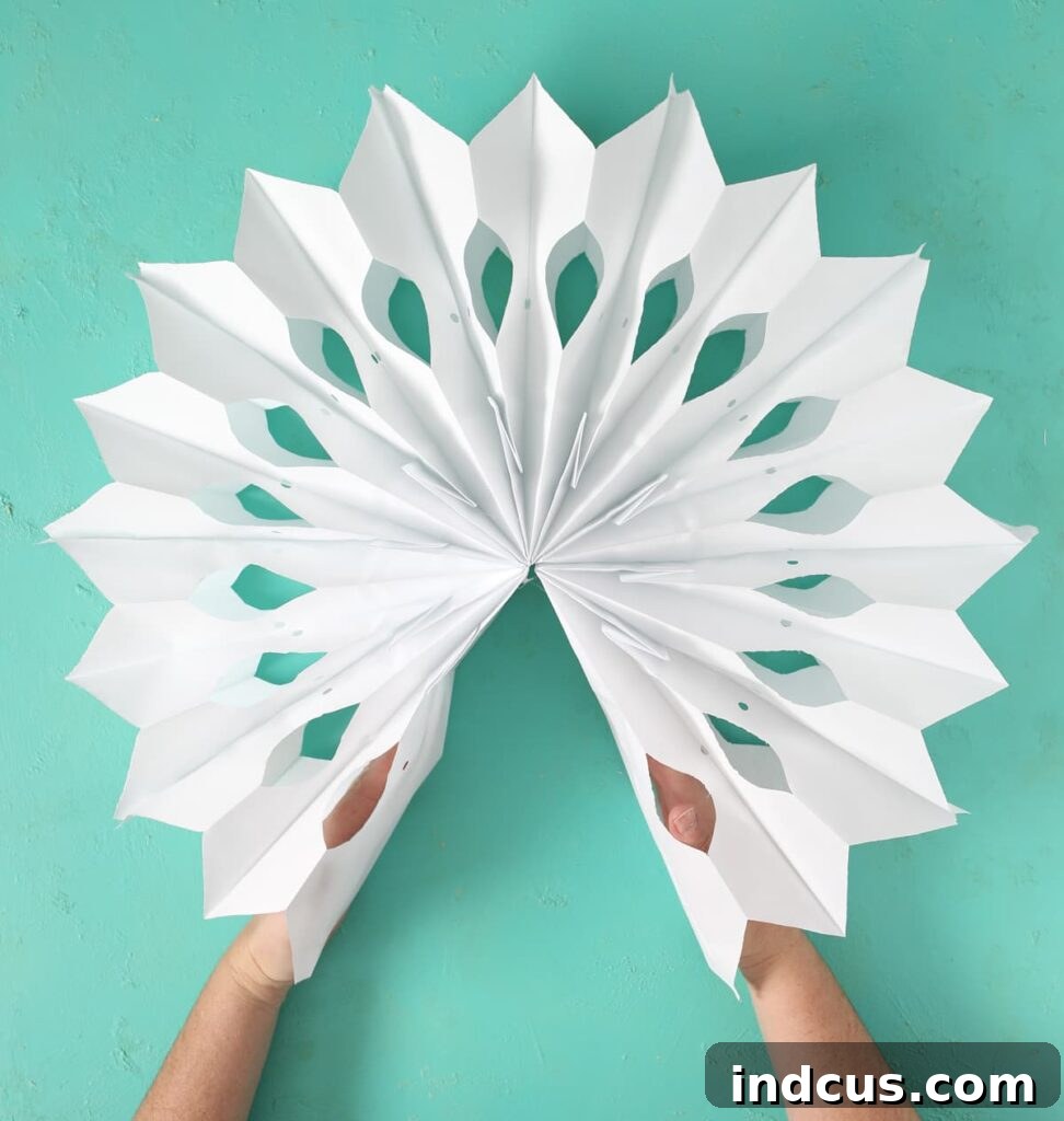 Glimmering Paper Star Lanterns 9 Demonstrating how to gently bring the ends of the paper bag stack together to form the 3D star