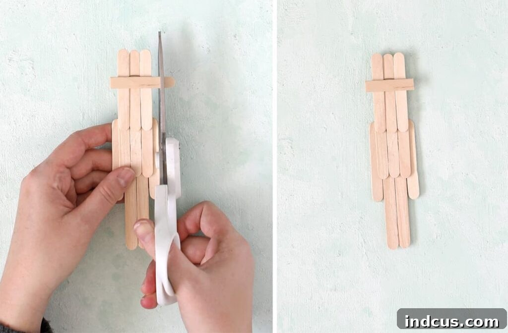 Close-up of hands using scissors to trim a popsicle stick for the leprechaun's hat brim, demonstrating precision cutting.