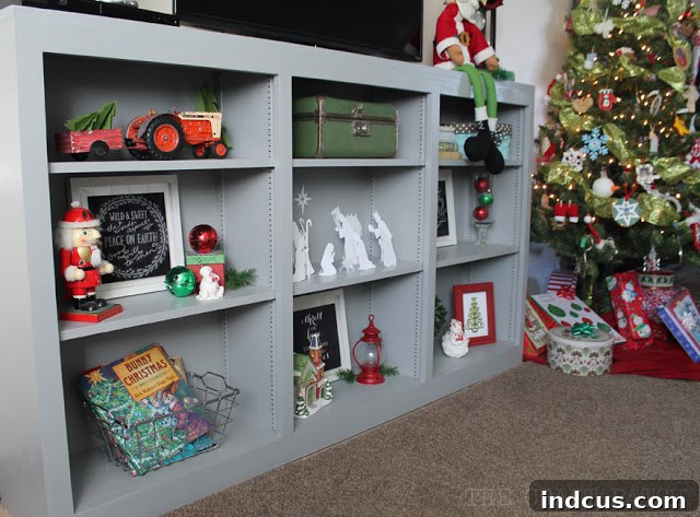 Our Christmas Wonderland 14 Media cabinet shelves artfully decorated for Christmas with a collection of festive items and seasonal displays.