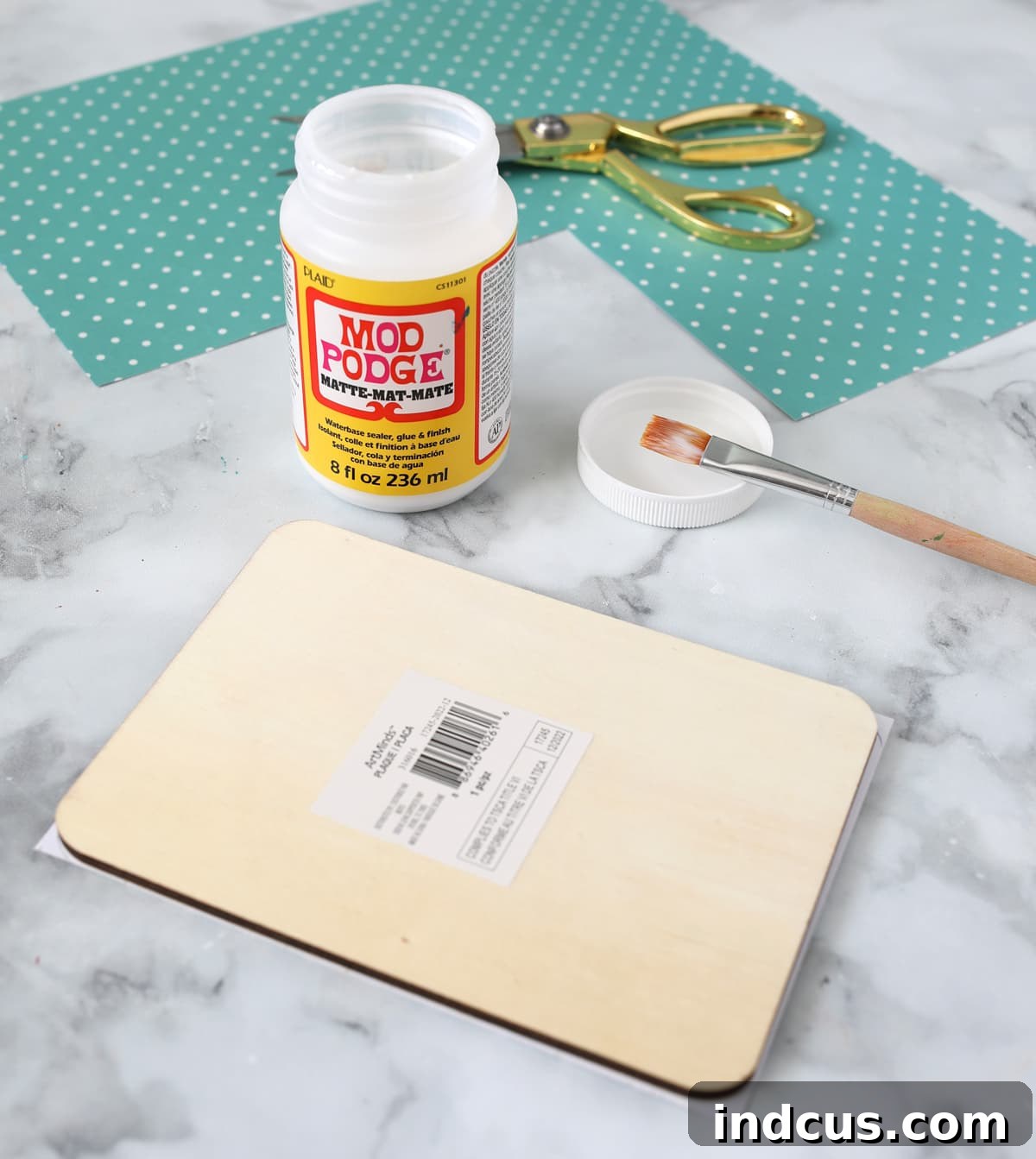 Applying Mod Podge to attach scrapbook paper to wood