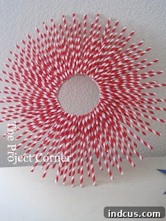 Patriotic wreath made from red and white paper straws arranged in a sunburst pattern