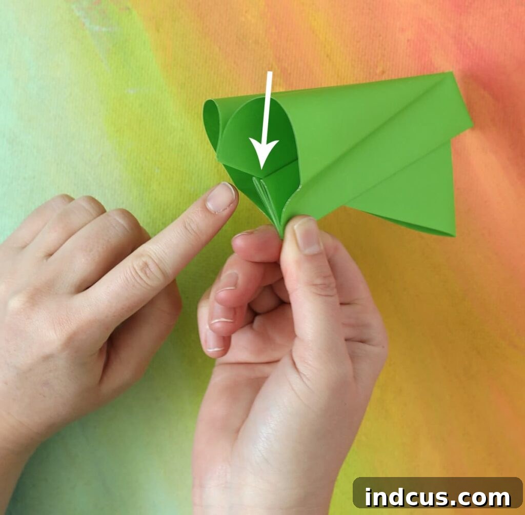 Demonstration of the correct grip and hand position to make a paper popper pop loudly and effectively.
