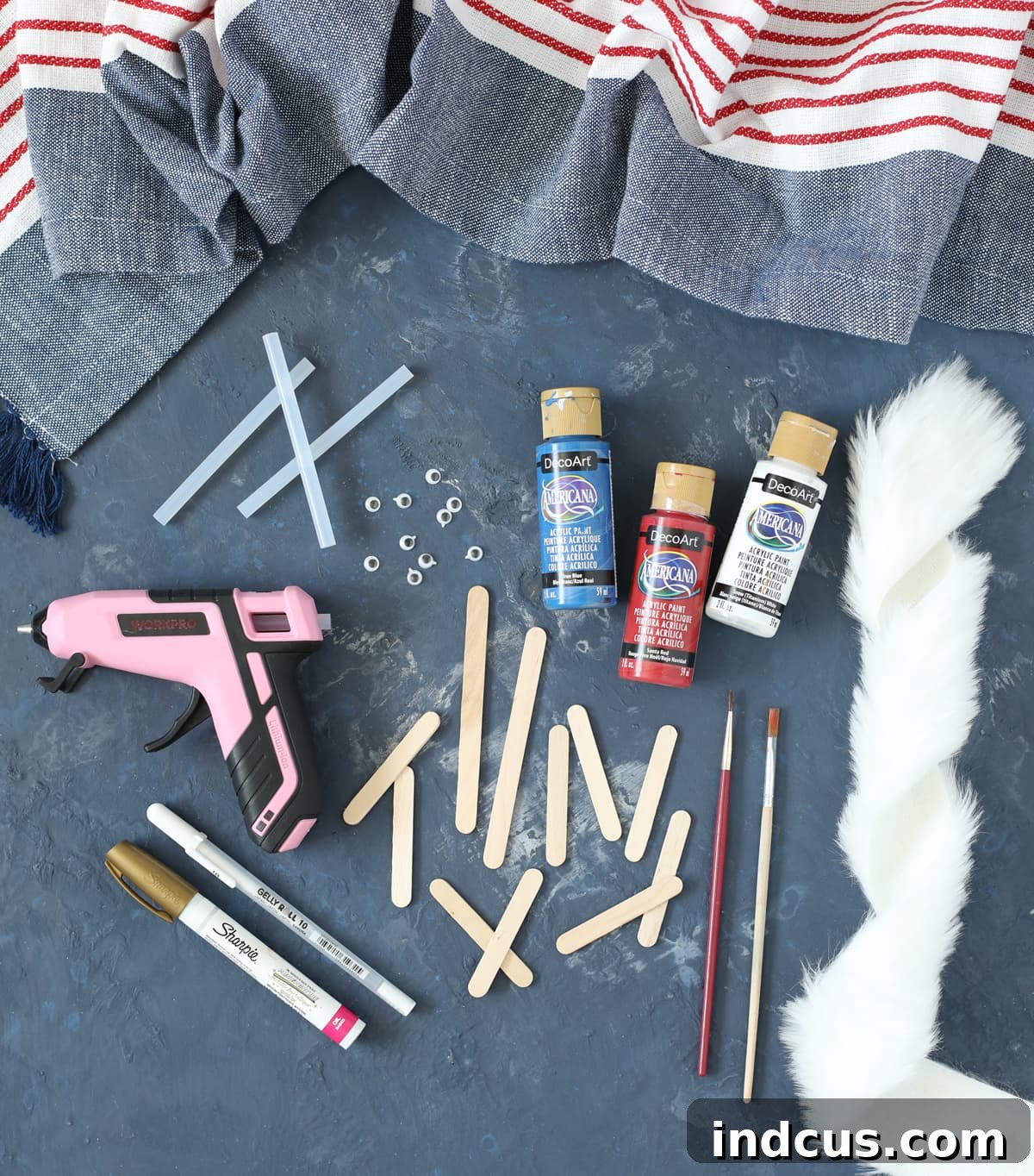 Collection of materials needed for a patriotic craft project, including various craft sticks, paints, and tools.