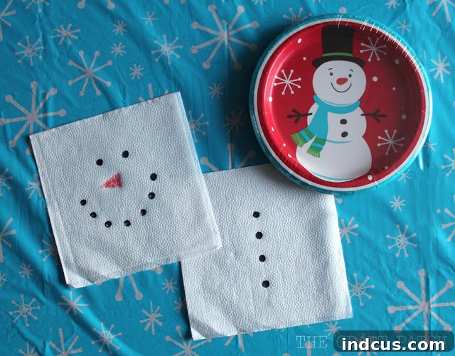 Easy DIY snowman napkins, crafted from plain white napkins with hand-drawn snowman faces and button details using a marker.