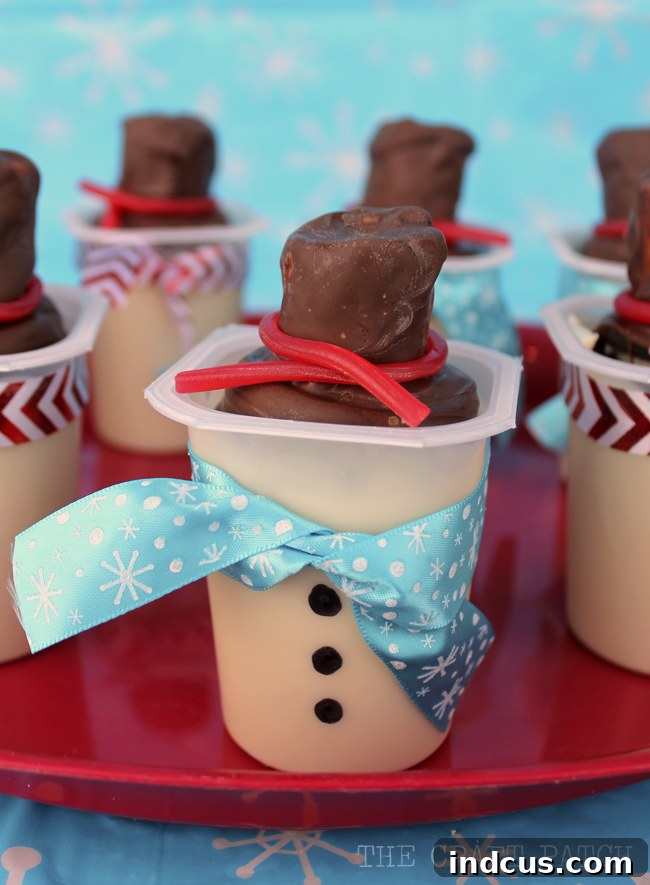 Finished edible snowman top hat treats featuring an Oreo cookie base, a fluffy marshmallow, and a decorative licorice band.