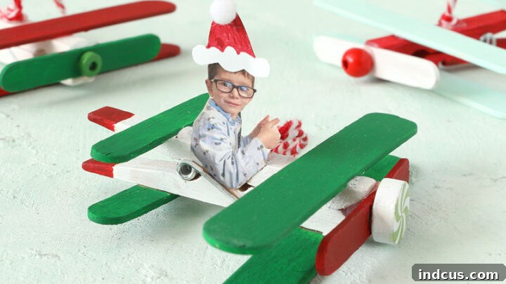 Popsicle stick airplane Christmas ornament featuring a child's photo