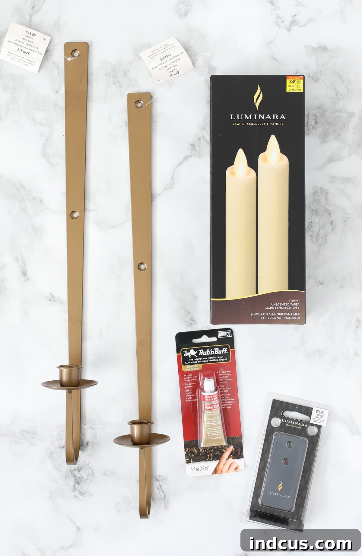 Warm Glow Wall Luminaires 3 Close-up of elegant bronze wall sconces, transformed with Rub n Buff for a luxurious gold finish, paired with realistic battery-powered LED tapered candles for a sophisticated home ambiance.
