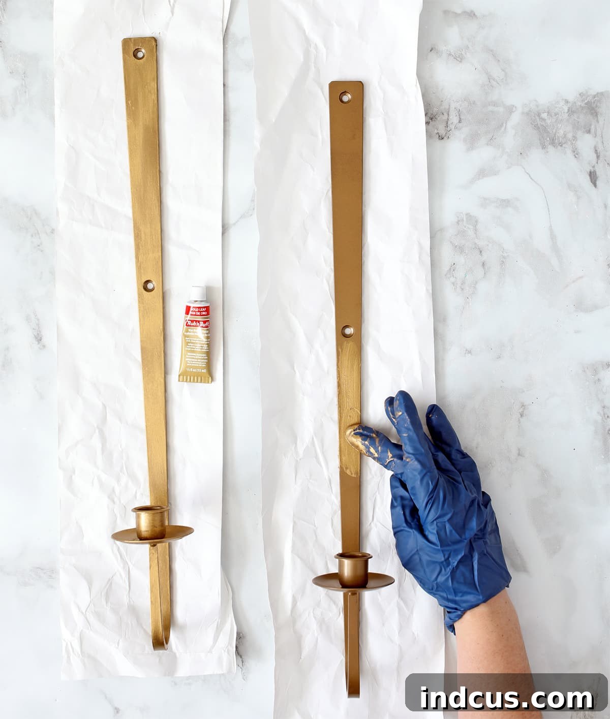 Warm Glow Wall Luminaires 4 Side-by-side comparison of a bronze wall sconce before and after applying Rub n Buff in Gold Leaf, showcasing the dramatic difference in luster and color tone for an enhanced home decor aesthetic.