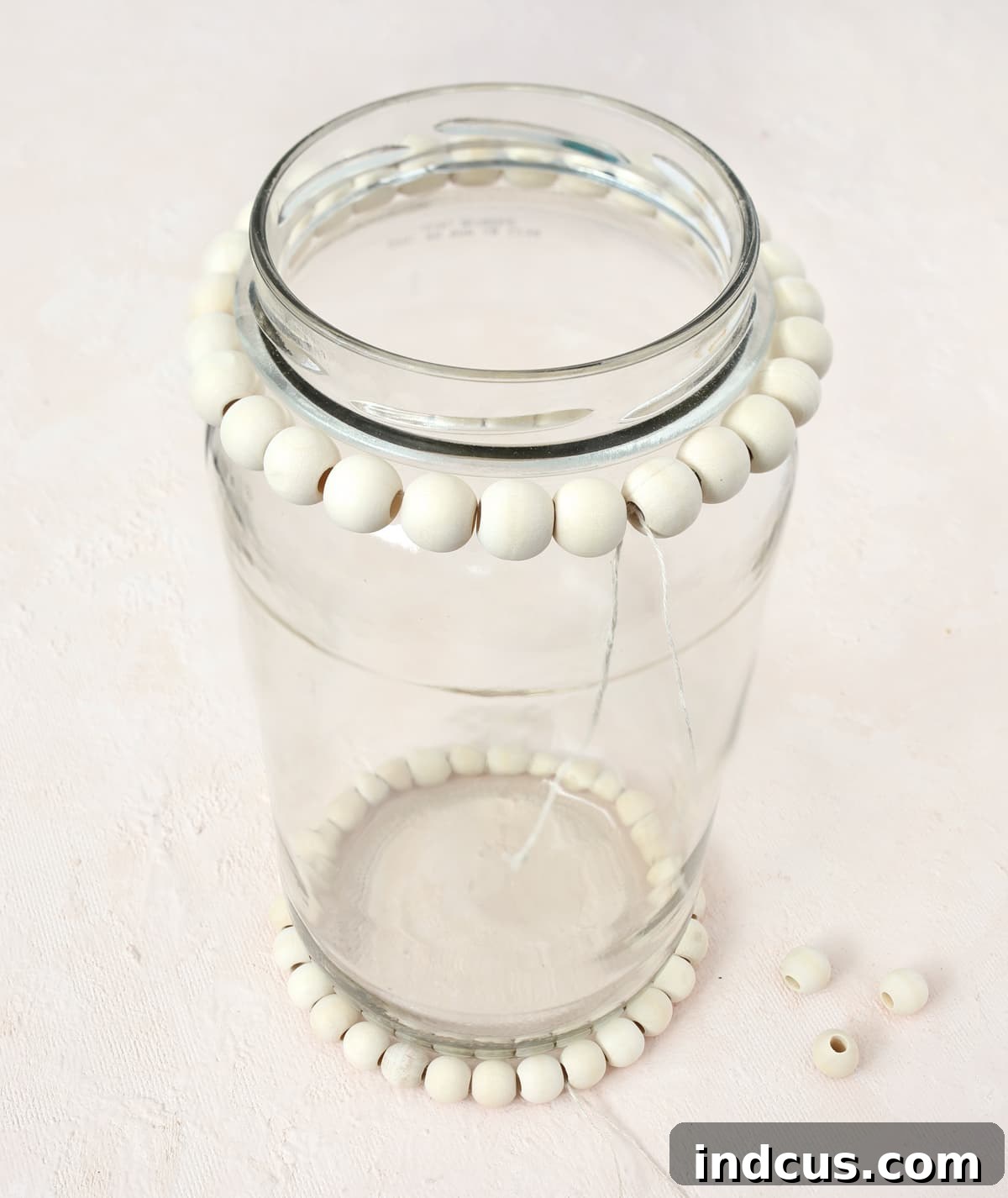 Crafting an upcycled glass jar decoration with wood beads