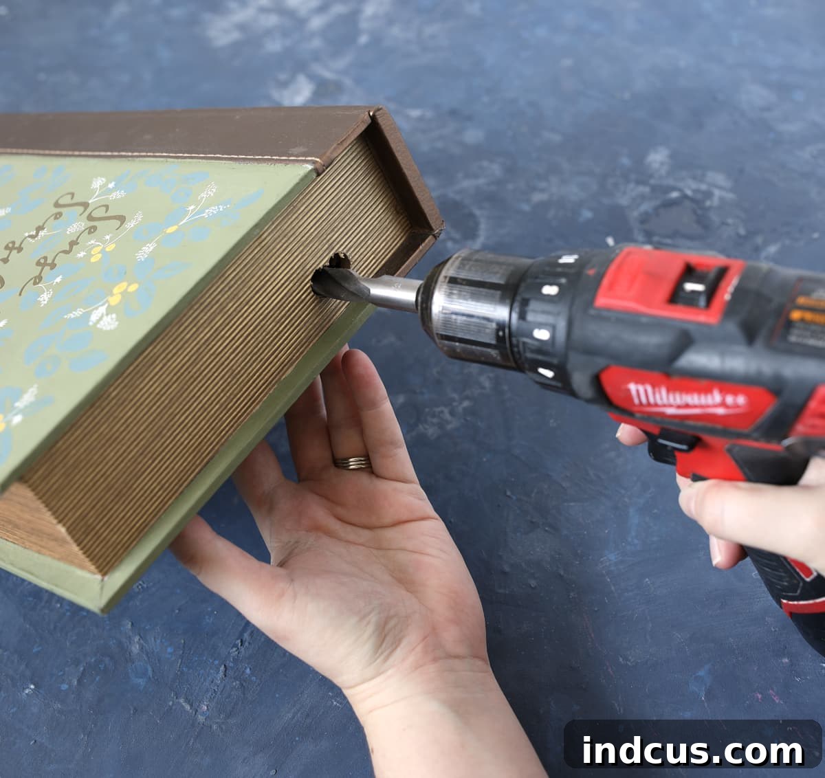 Secret Book Box Charging Hub 5 Detail shot of a drill creating a neat hole in the back panel of a decorative book box