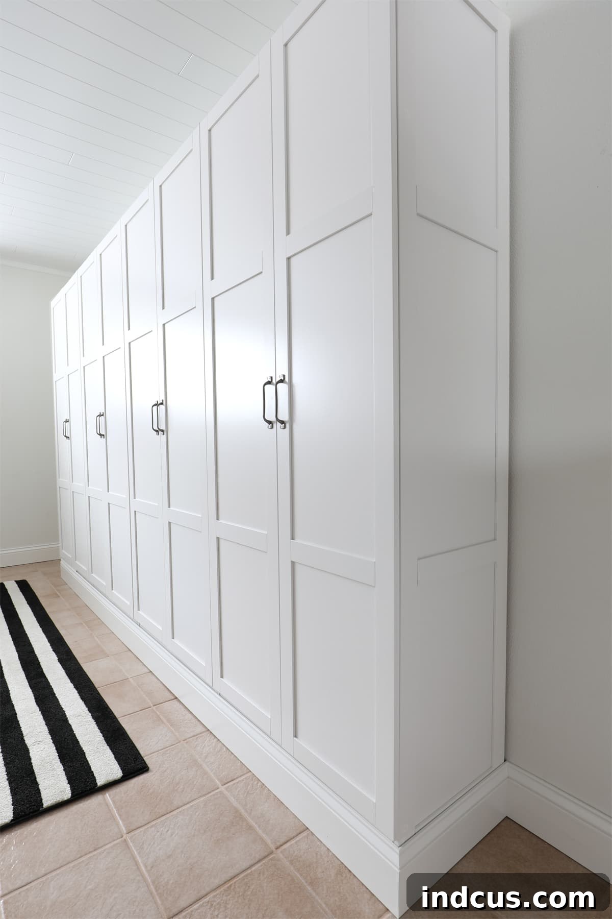 Full view of the transformed craft room with a large, integrated cabinet storage wall from Sauder units