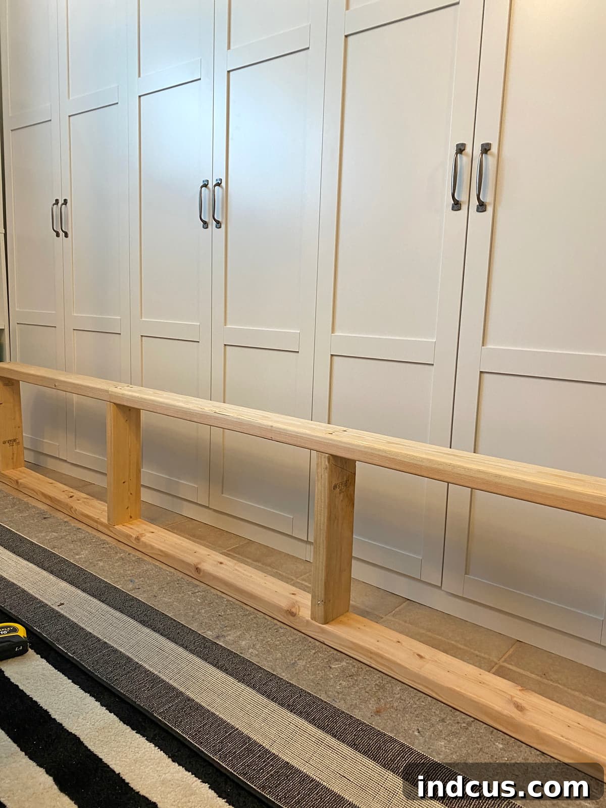 Custom-built 2x4 lumber base platform for supporting DIY built-in cabinets
