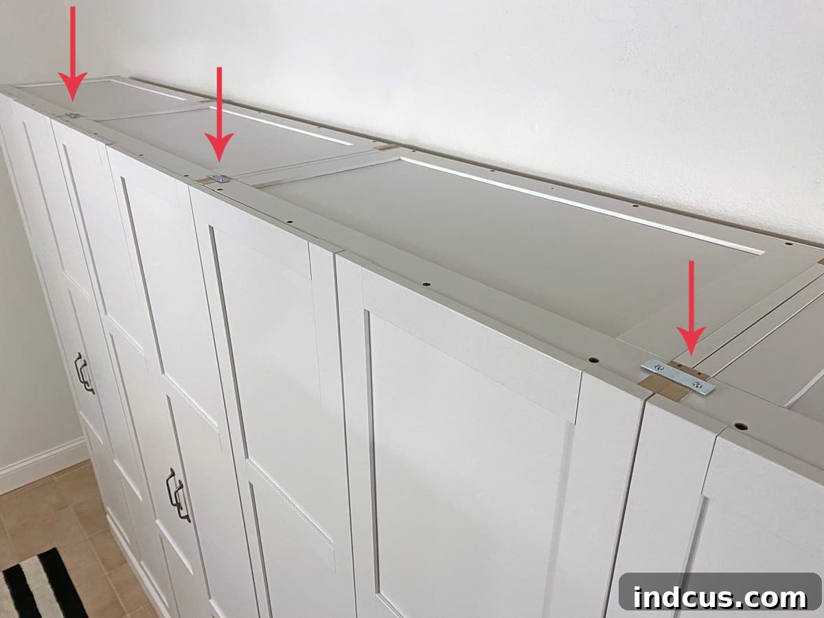 Installing flat metal brackets on top of Sauder cabinets to securely connect them for a built-in look