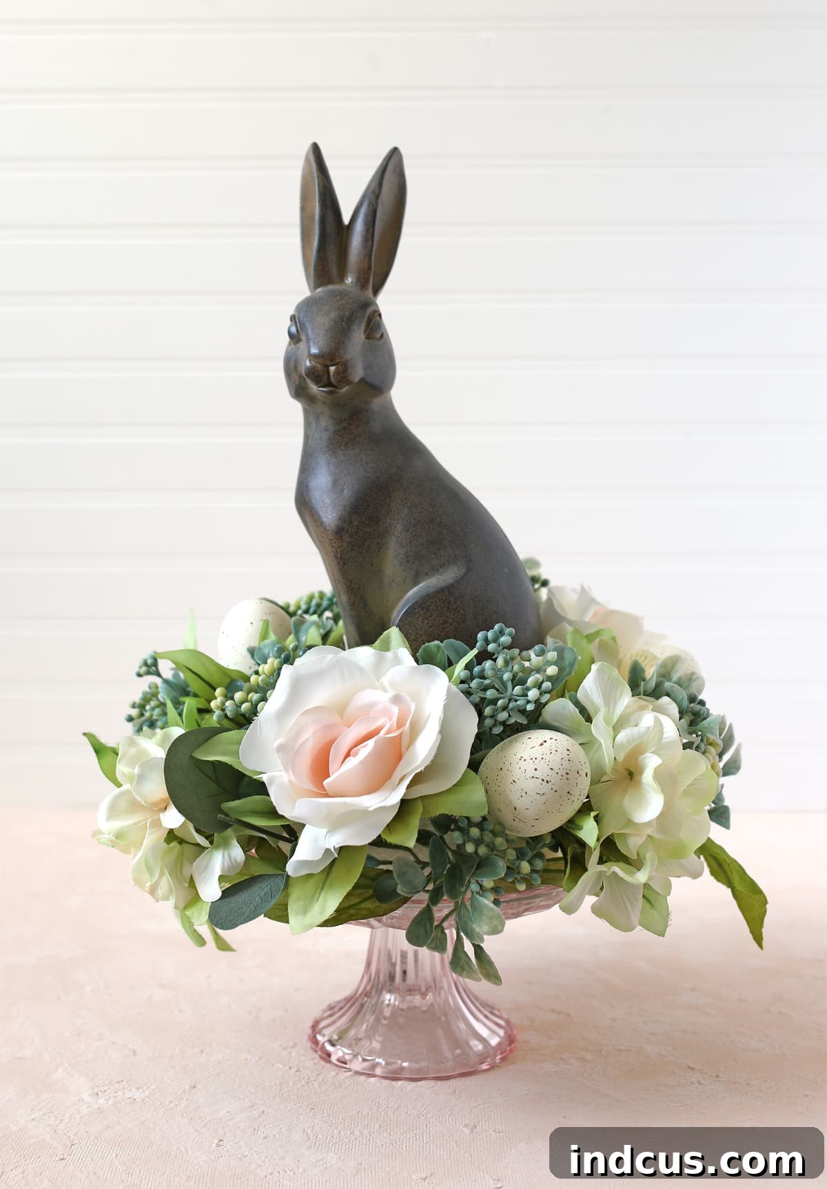 Subdued spring centerpiece idea with a neutral bunny and cream-colored flowers, perfect for elegant decor