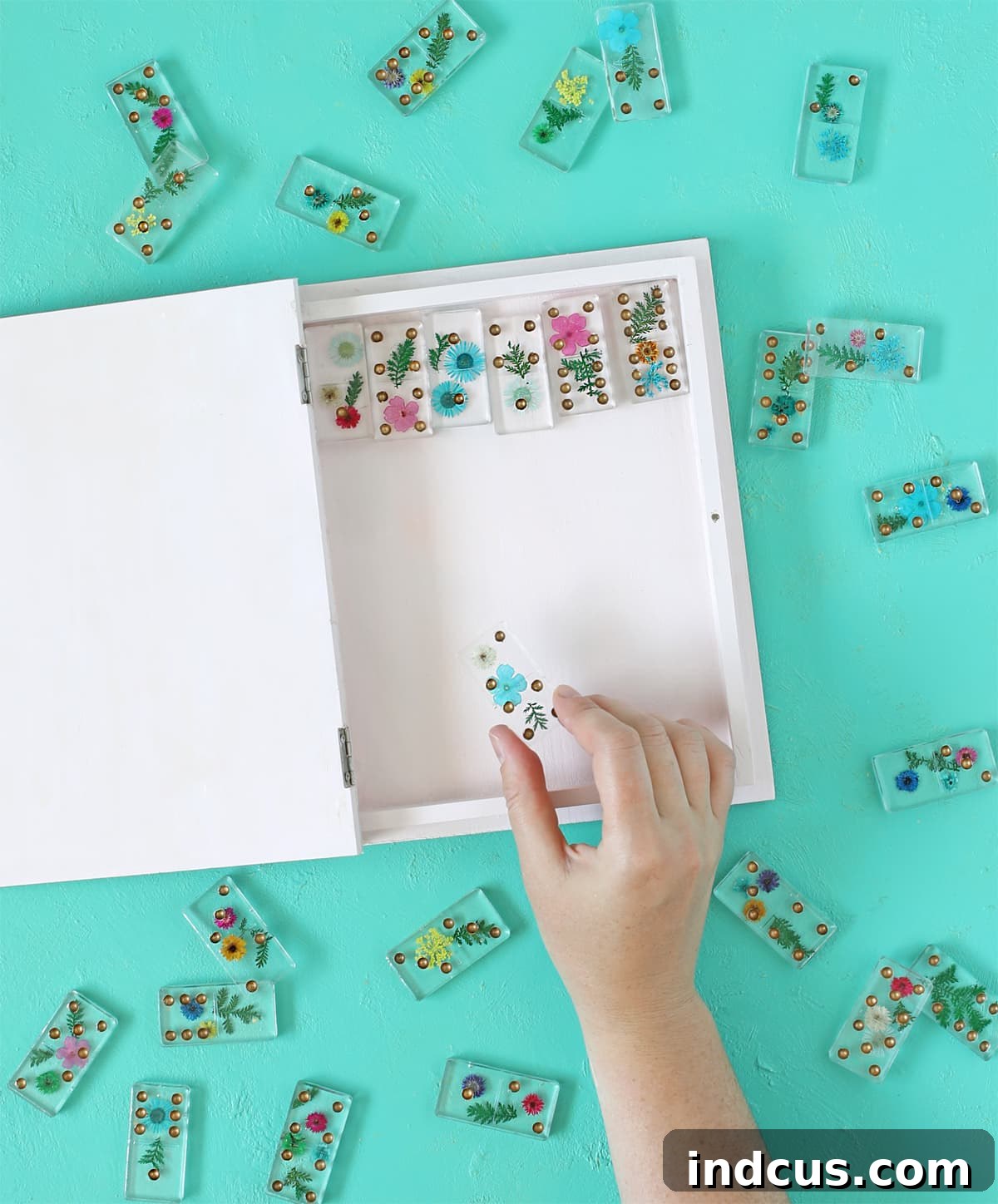 Close-up of a finished DIY resin domino set featuring clear epoxy and vibrant pressed flowers, elegantly displayed.