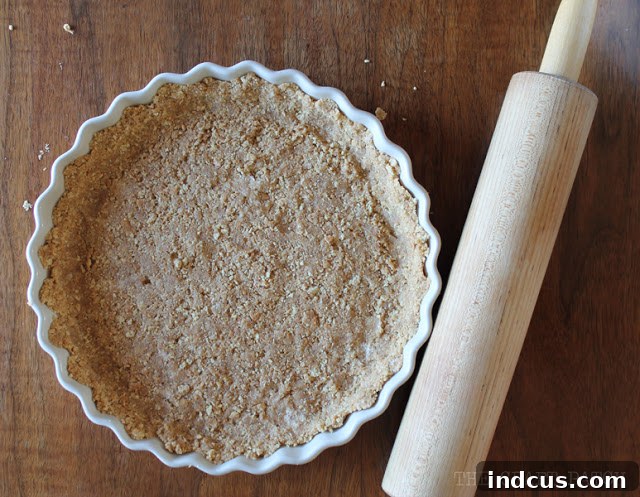 A perfectly formed and chilled graham cracker pie crust in a deep dish, ready for filling