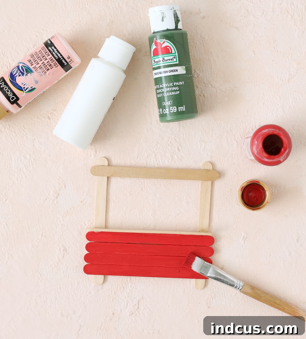 Popsicle sticks painted in vibrant Christmas colors for craft