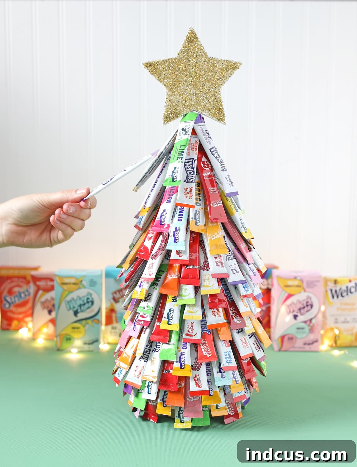 A guest selecting a drink flavor packet from the completed Christmas tree.