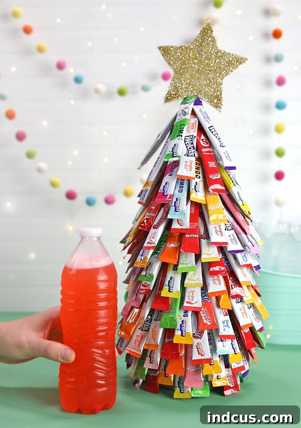 A person enjoying a flavored water drink mixed from a packet from the Christmas tree.