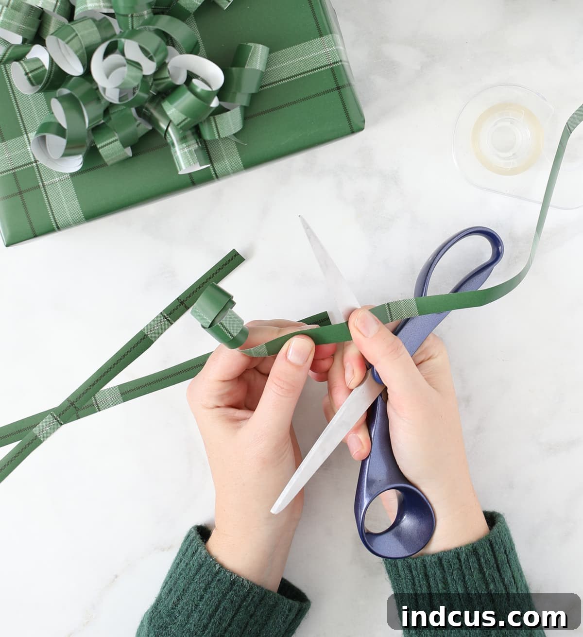 Step-by-step guide: Curling leftover wrapping paper into a festive bow for DIY gift toppers.
