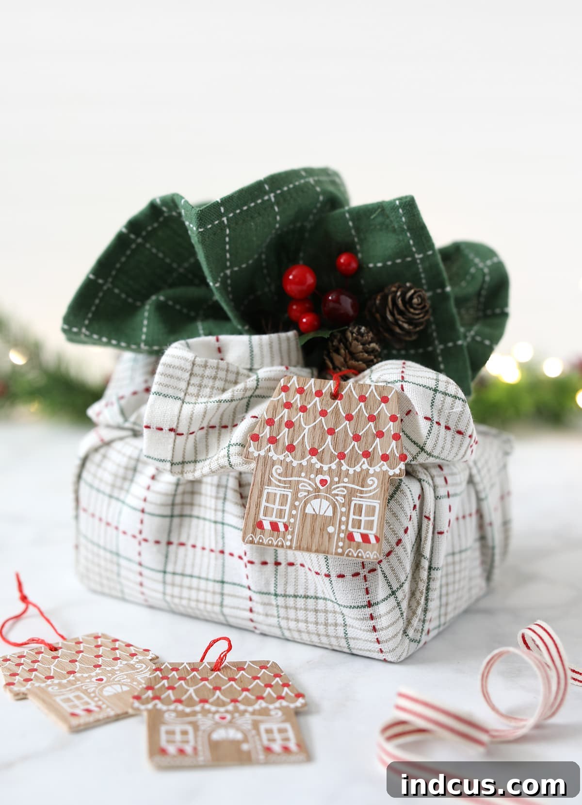 Beautifully wrapped gift using tea towels, adorned with berries and a tag