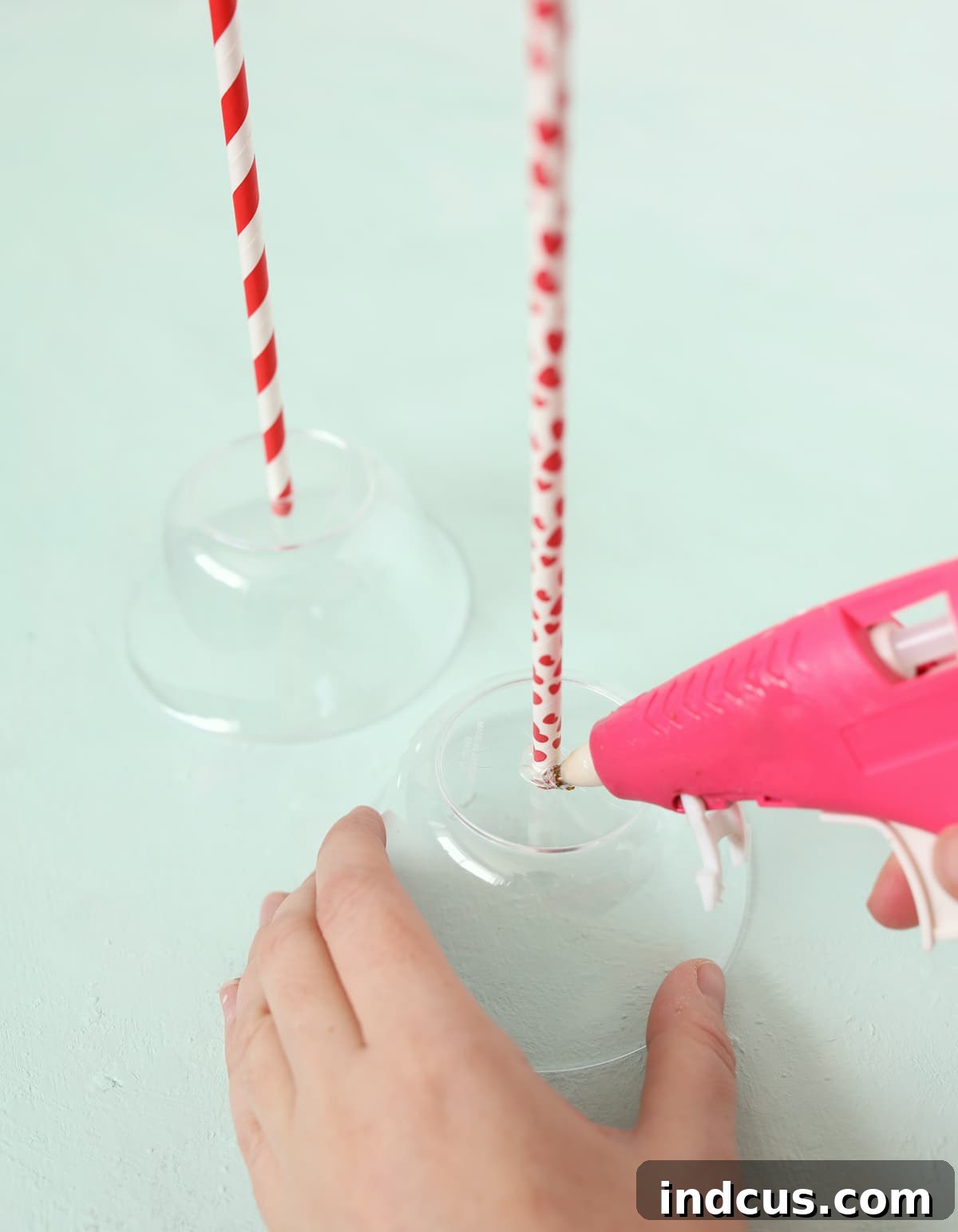 A paper straw is inserted into the plastic bowl and secured with a ring of hot glue for a sturdy lollipop stick.